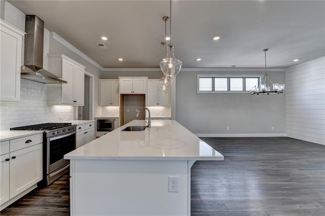 kitchen with stainless steel appliances, dark wood-style flooring, a sink, ornamental molding, and wall chimney range hood