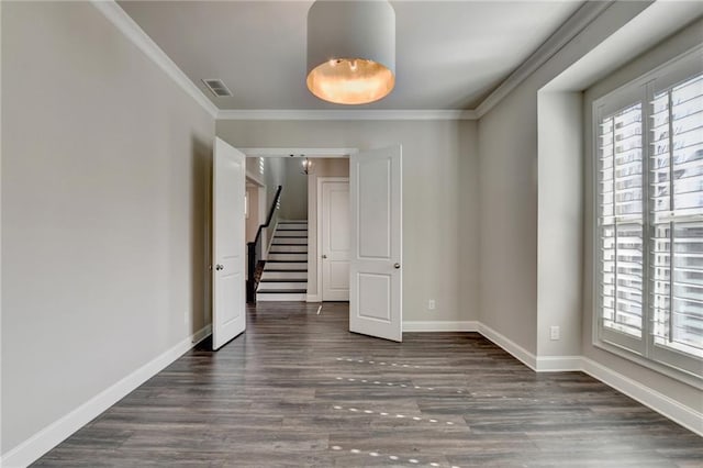 spare room featuring baseboards, ornamental molding, visible vents, and a healthy amount of sunlight