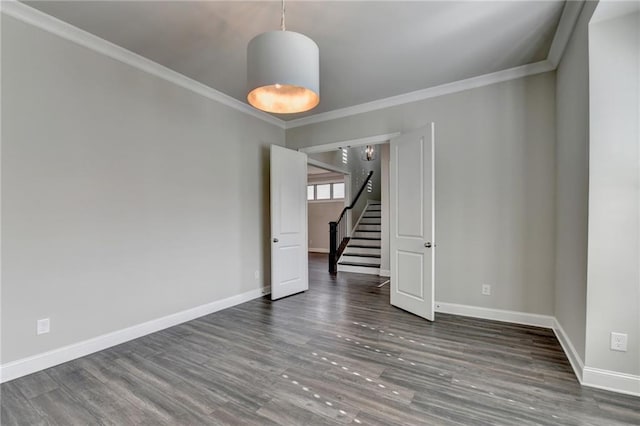 unfurnished room featuring ornamental molding, stairway, baseboards, and wood finished floors