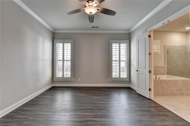 spare room with dark wood-style floors, a healthy amount of sunlight, and crown molding