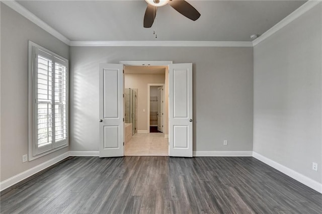 unfurnished room with baseboards, ornamental molding, and dark wood-type flooring