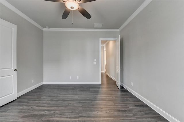 spare room featuring dark wood-type flooring, ornamental molding, and baseboards