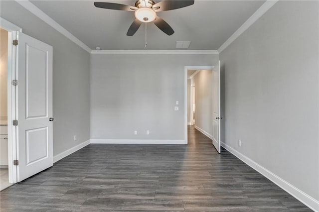 spare room with baseboards, dark wood-type flooring, and crown molding