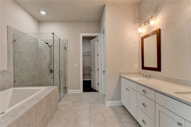 full bathroom with double vanity, a sink, a spacious closet, a shower stall, and a bath