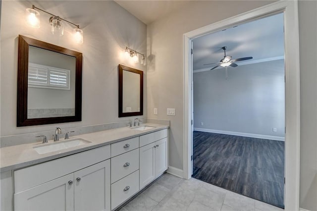 bathroom with ceiling fan, a sink, baseboards, and double vanity