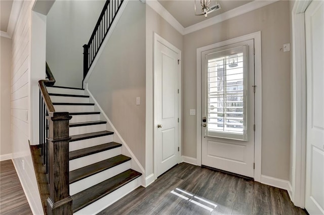 foyer entrance featuring crown molding, dark wood-type flooring, stairs, and baseboards