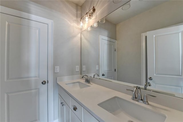 bathroom featuring a sink and double vanity