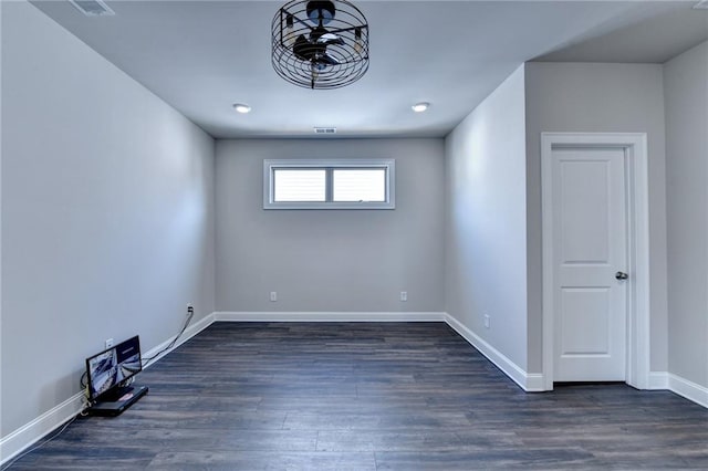 spare room featuring baseboards, visible vents, and dark wood-style flooring