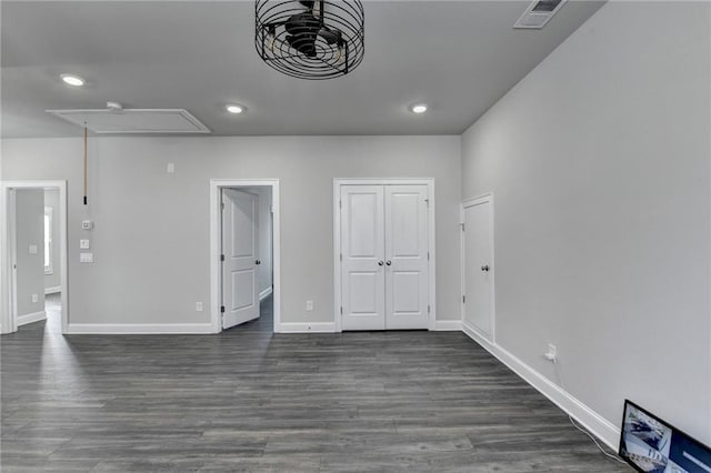 empty room with recessed lighting, visible vents, baseboards, dark wood finished floors, and attic access