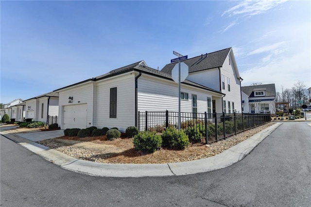 view of side of home with an attached garage, a chimney, and fence