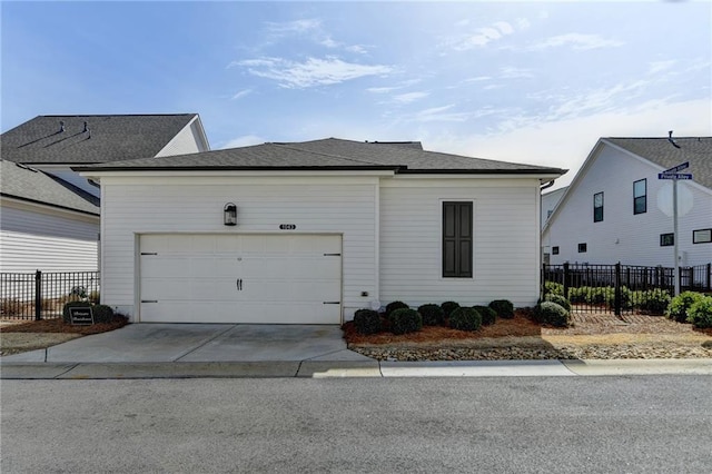 view of front of home featuring an attached garage, fence, and concrete driveway