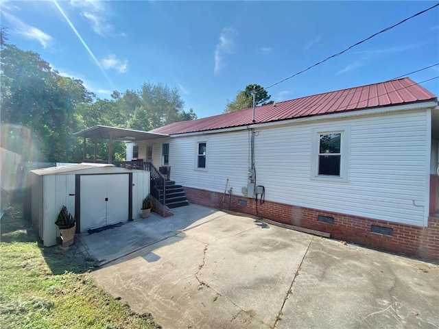 rear view of house featuring a shed and a patio area