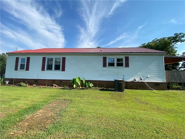 rear view of property featuring a yard and central AC unit