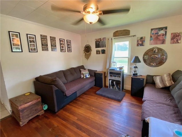 living room featuring dark hardwood / wood-style flooring, crown molding, and ceiling fan