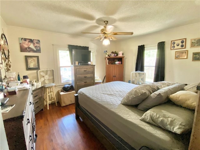 bedroom featuring dark hardwood / wood-style flooring, ceiling fan, and a textured ceiling