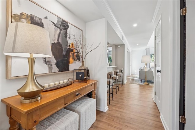 hall with baseboards, ornamental molding, wood finished floors, and recessed lighting