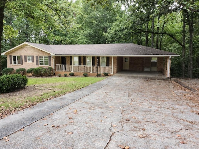 ranch-style home featuring a carport and covered porch