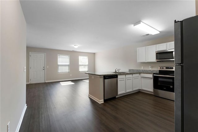 64 Middleton Ct, Chatsworth, GA 30705 - kitchen with stainless steel appliances, a peninsula, white cabinets, dark wood-type flooring, and open floor plan