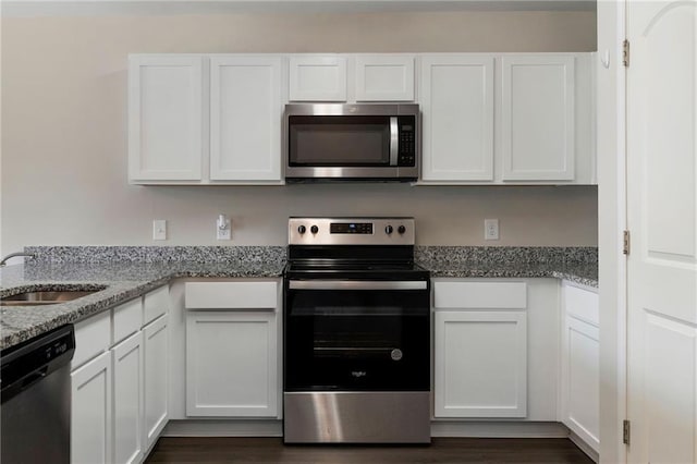 64 Middleton Ct, Chatsworth, GA 30705 - kitchen featuring appliances with stainless steel finishes, white cabinets, light stone countertops, and dark wood-style flooring