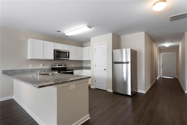 64 Middleton Ct, Chatsworth, GA 30705 - kitchen featuring stainless steel appliances, a peninsula, dark wood-style floors, white cabinetry, and stone countertops