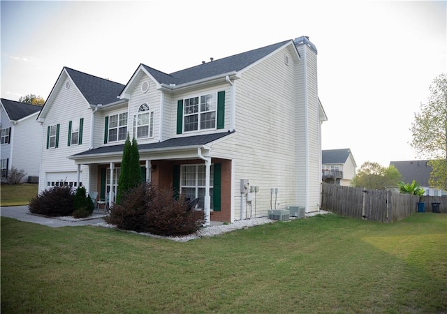 view of front facade featuring central air condition unit, a front lawn, and a garage