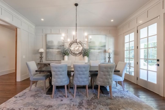 dining space with a notable chandelier, crown molding, and dark wood-type flooring