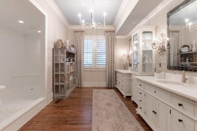 bathroom with hardwood / wood-style floors, vanity, crown molding, and a notable chandelier