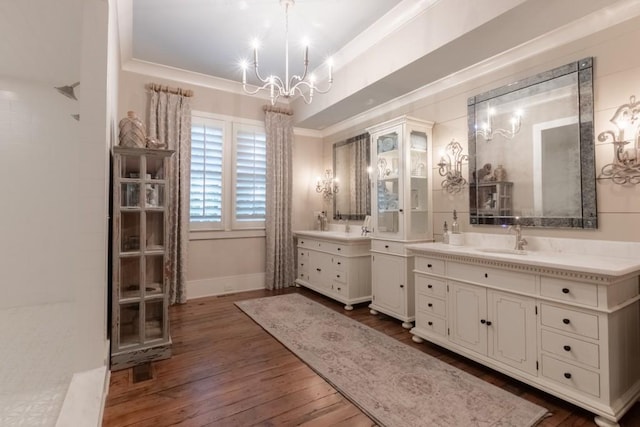 bathroom with a chandelier, hardwood / wood-style floors, vanity, and ornamental molding