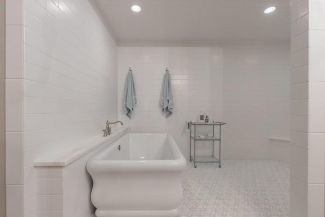 bathroom with a bath and tile walls