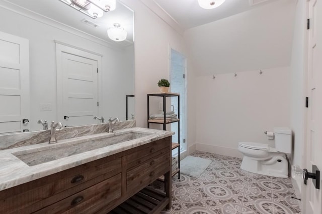 bathroom with tile patterned floors, vanity, toilet, and crown molding