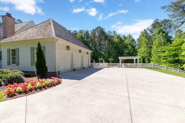 view of home's exterior with a pergola and a garage