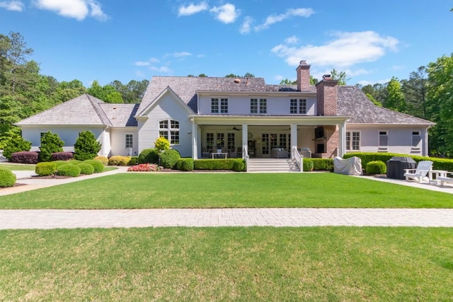 view of front facade with a front yard, ceiling fan, and covered porch