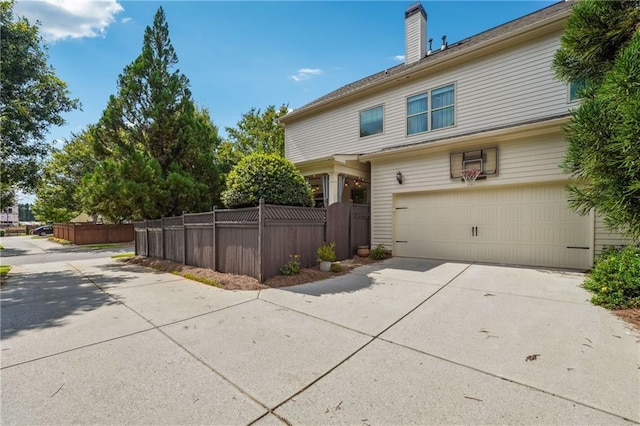 715 Saybeck Way, Milton, GA 30004 - view of home's exterior featuring an attached garage, driveway, and a chimney