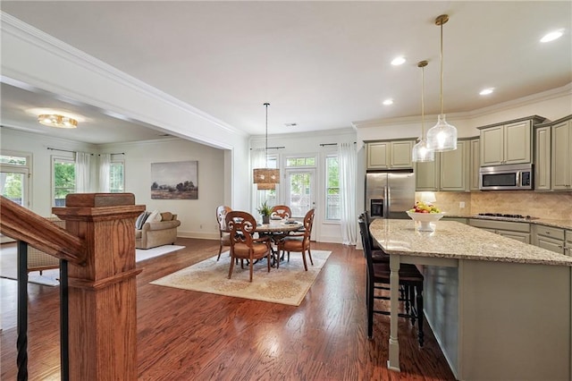 715 Saybeck Way, Milton, GA 30004 - kitchen featuring stainless steel appliances, a center island, a breakfast bar area, ornamental molding, and tasteful backsplash