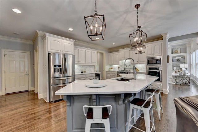 kitchen featuring white cabinets, decorative light fixtures, stainless steel appliances, and a spacious island