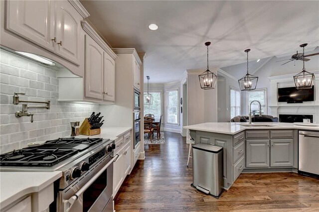 kitchen featuring pendant lighting, white cabinets, sink, ceiling fan, and appliances with stainless steel finishes