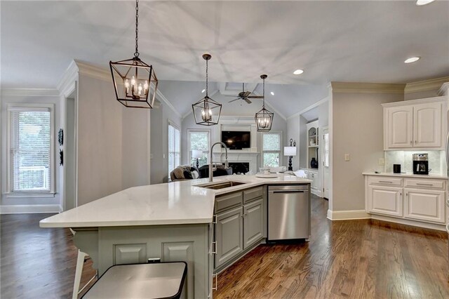 kitchen with white cabinets, stainless steel dishwasher, a kitchen island with sink, and sink