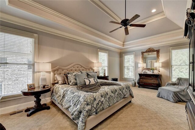 bedroom featuring multiple windows, a raised ceiling, ceiling fan, and ornamental molding