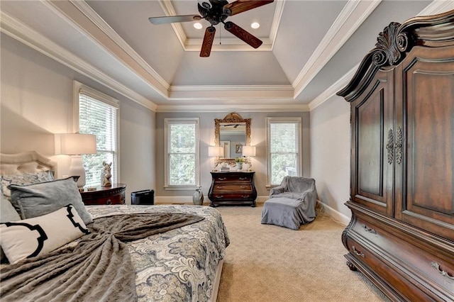 bedroom featuring ceiling fan, light colored carpet, crown molding, and a tray ceiling