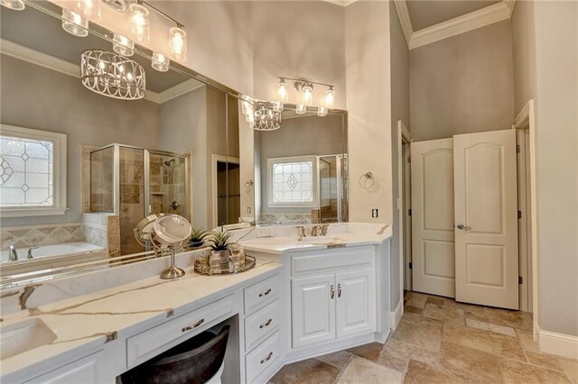 bathroom featuring shower with separate bathtub, vanity, crown molding, and a notable chandelier