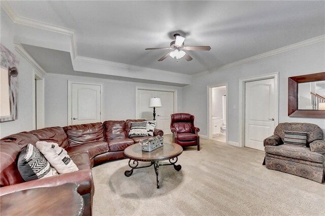 living room featuring light carpet, ceiling fan, and ornamental molding