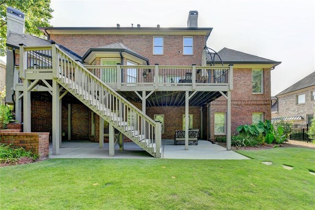 rear view of property featuring a patio area, a yard, and a wooden deck