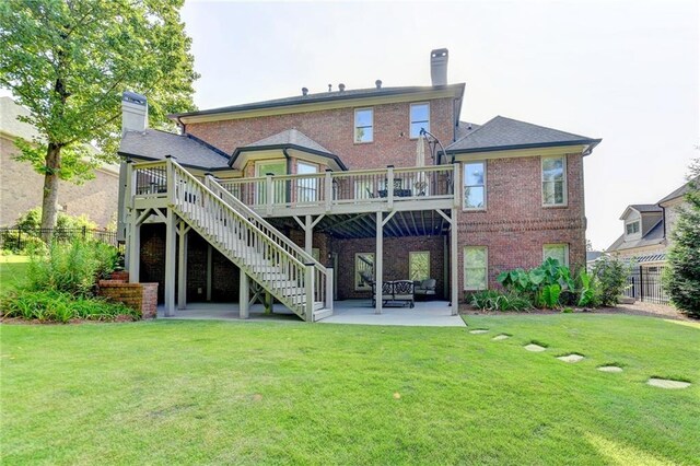 rear view of house featuring a yard, a patio, and a wooden deck