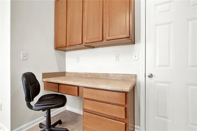 kitchen with ceiling fan, light carpet, a center island, light countertops, and brown cabinets