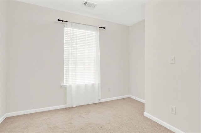 carpeted spare room featuring baseboards