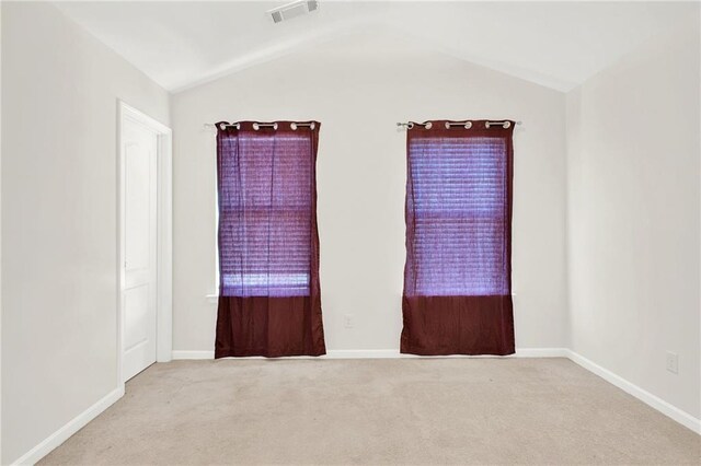 spare room featuring baseboards and light colored carpet