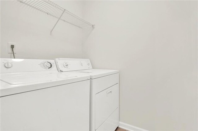 laundry area with laundry area, washing machine and clothes dryer, and baseboards