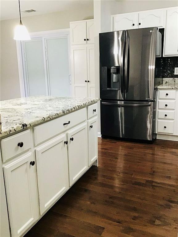 3535 Cameron Cir, Gainesville, GA 30506 - kitchen featuring fridge with ice dispenser, dark wood-style flooring, light stone counters, and white cabinetry