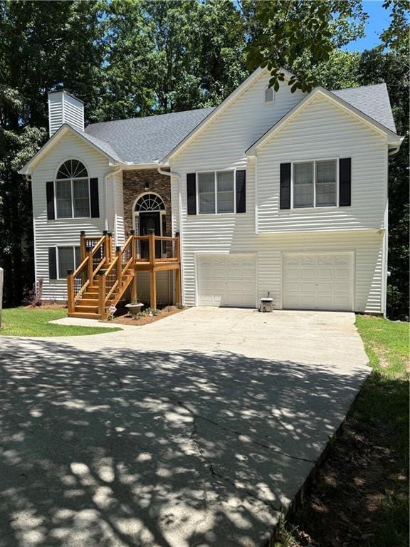 3535 Cameron Cir, Gainesville, GA 30506 - split foyer home featuring a garage, concrete driveway, a chimney, stairway, and covered porch