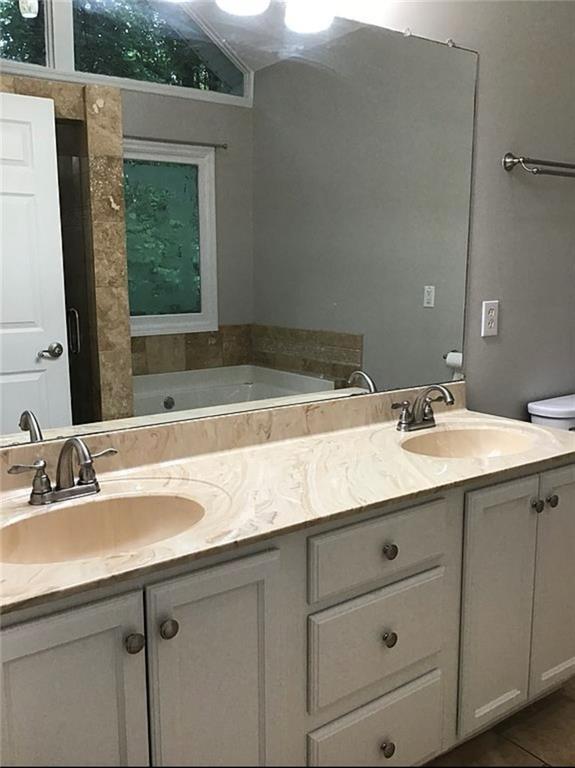 3535 Cameron Cir, Gainesville, GA 30506 - full bath with double vanity, a garden tub, tile patterned flooring, and toilet